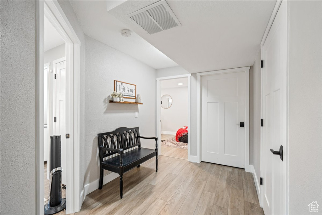 Hallway featuring light wood finished floors and baseboards