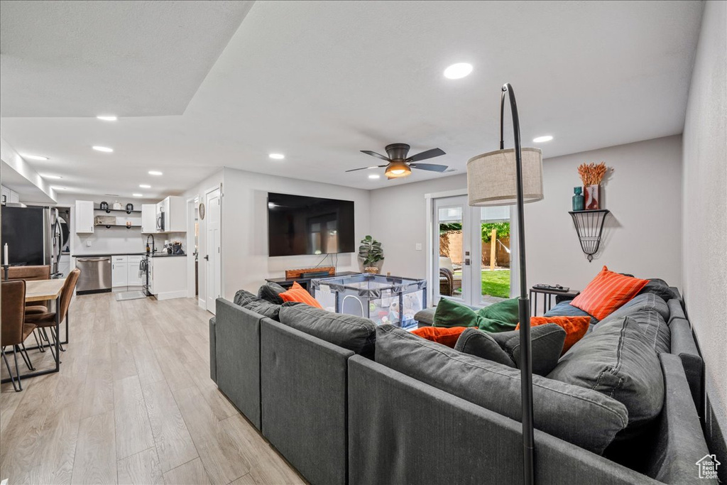 Living area with light wood-style floors, a ceiling fan, and recessed lighting