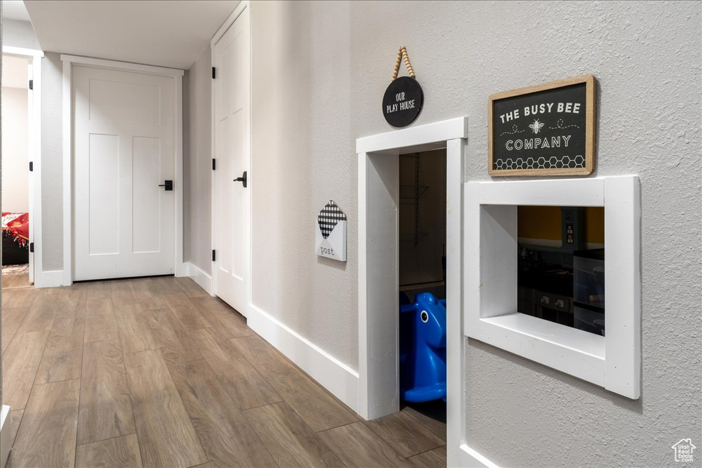 Hallway with wood finished floors and a textured wall