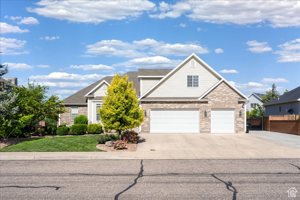 Traditional home with concrete driveway, brick siding, and an attached garage