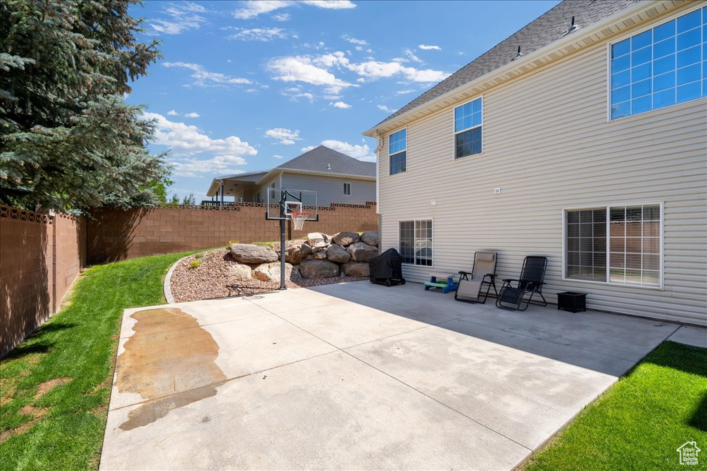 Back of property featuring a fenced backyard, a patio area, and a shingled roof