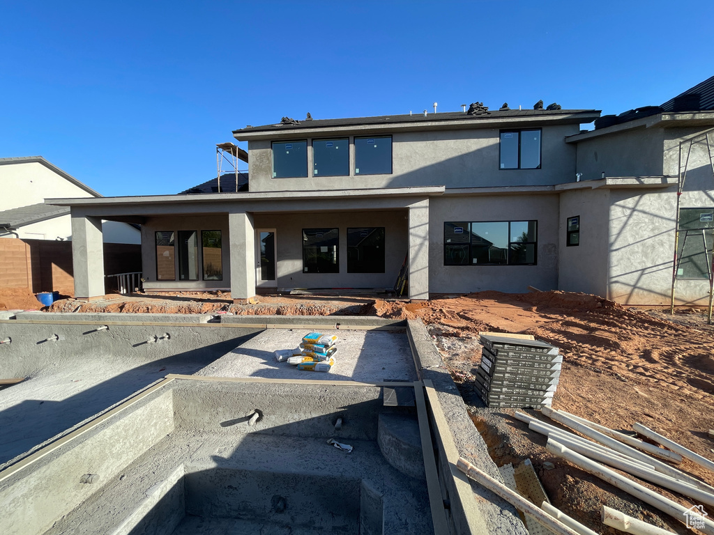 Rear view of property featuring stucco siding and a patio area