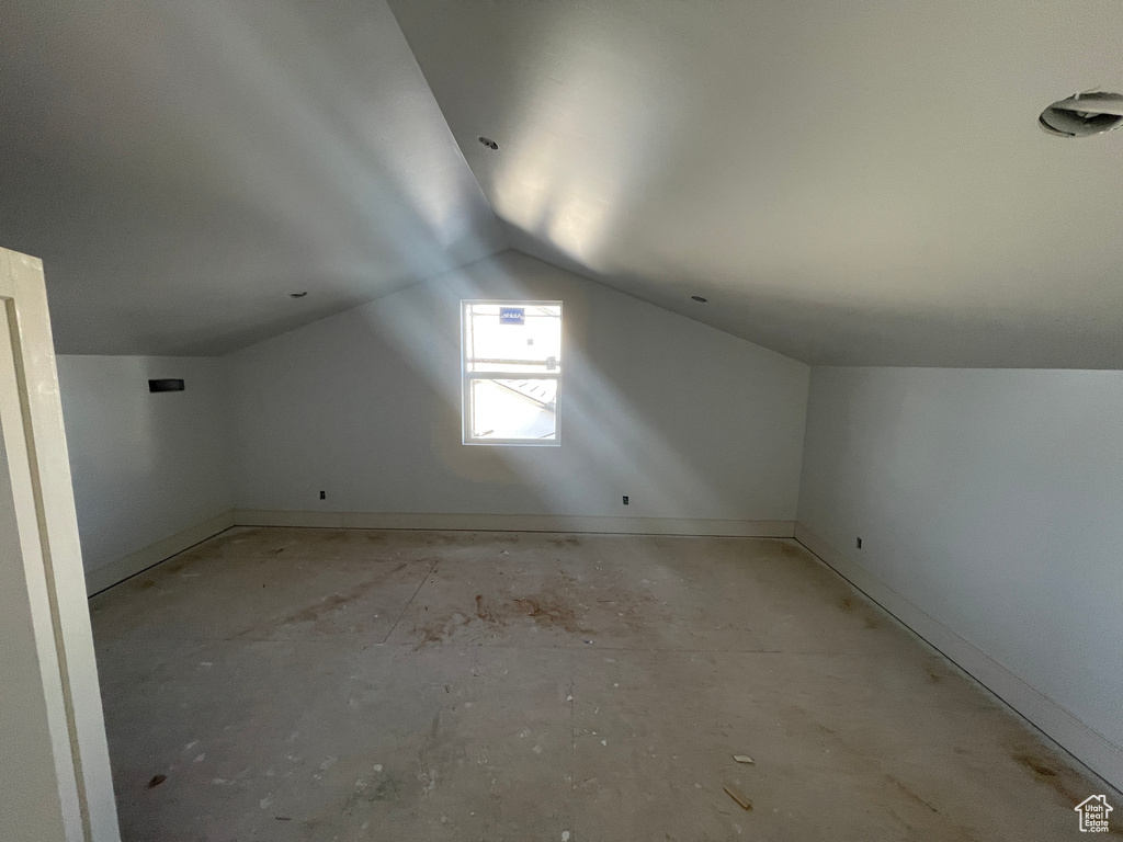 Bonus room with lofted ceiling and baseboards