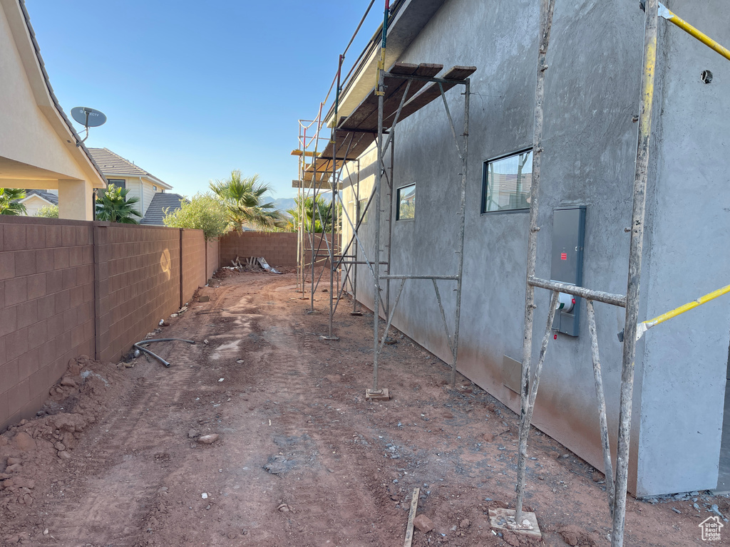 View of property exterior with a fenced backyard, stucco siding, and electric panel