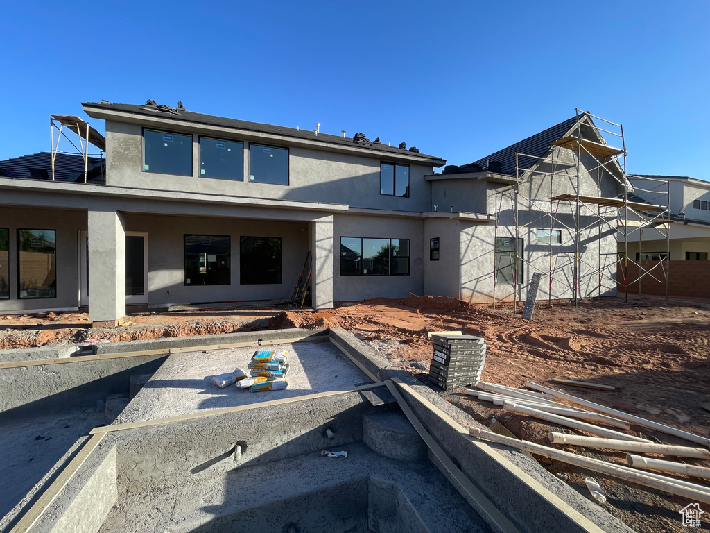 Rear view of house featuring stucco siding and a patio area