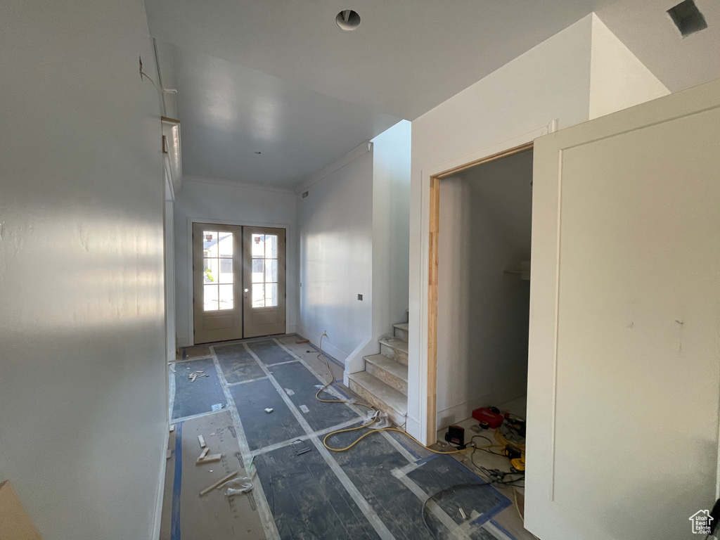 Foyer with french doors, stairs, and ornamental molding