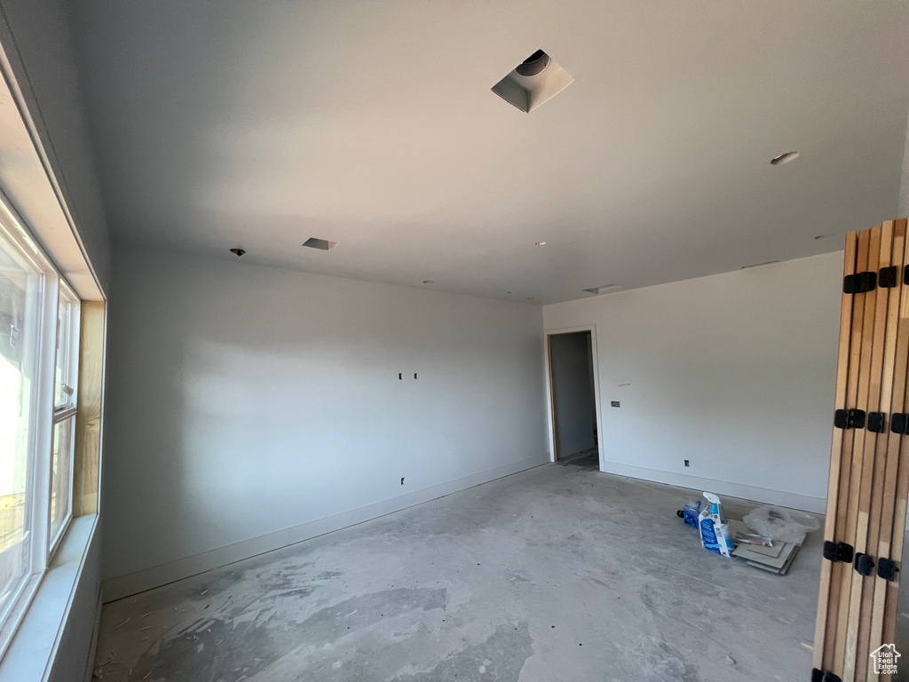 Unfurnished room featuring unfinished concrete flooring and baseboards