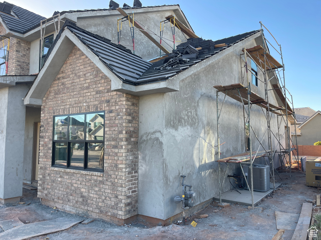 View of property exterior with stucco siding and brick siding