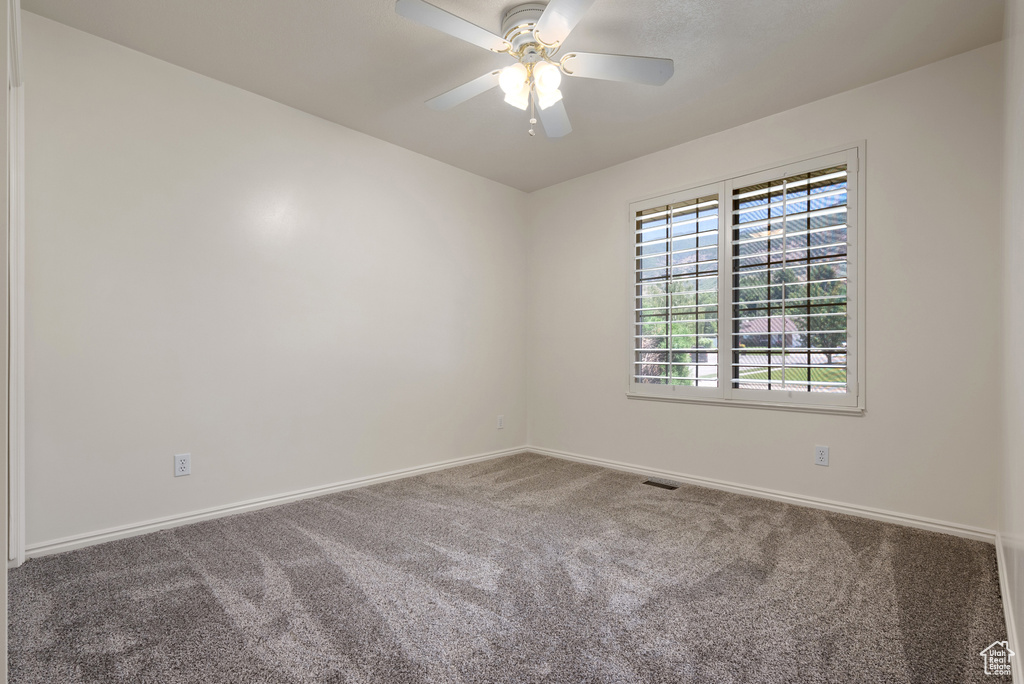 Spare room featuring carpet floors and ceiling fan
