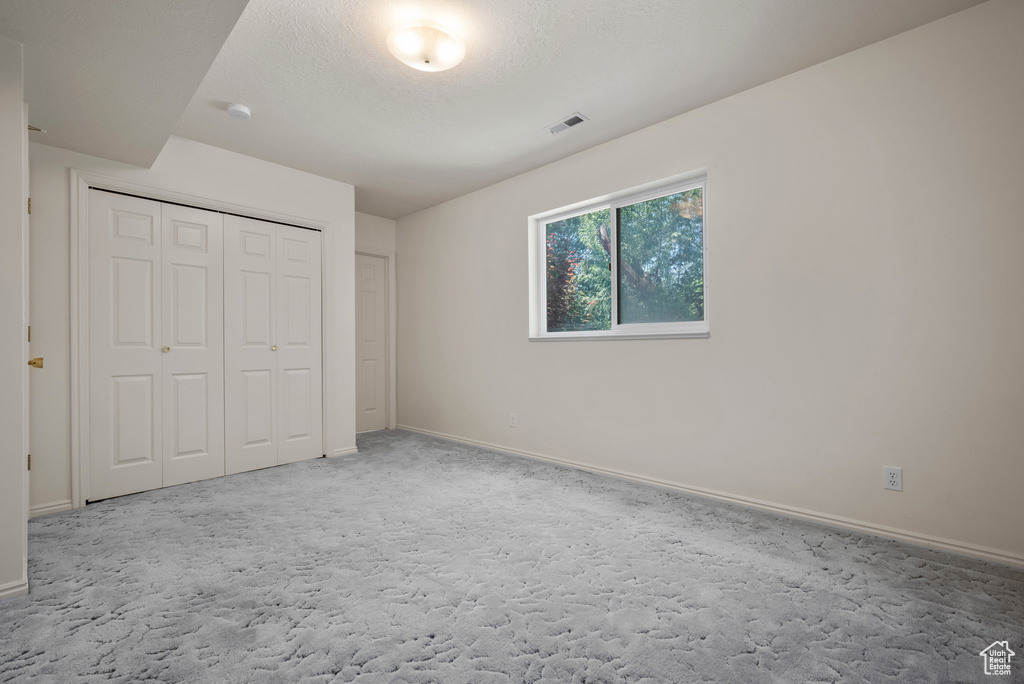 Unfurnished bedroom with carpet and a closet
