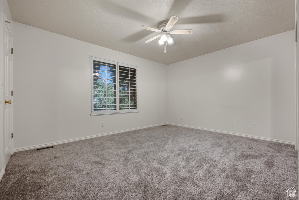 Spare room with ceiling fan and carpet flooring