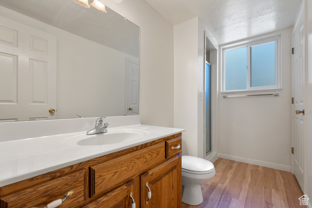 Full bath with vanity, wood finished floors, and a shower stall