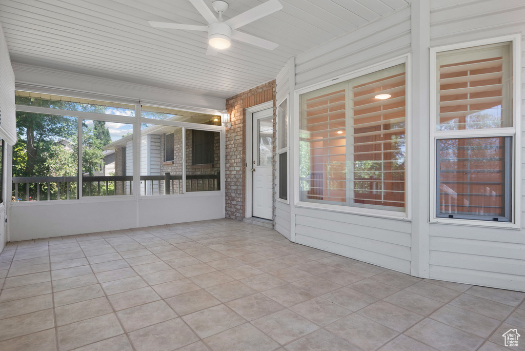 Unfurnished sunroom with ceiling fan