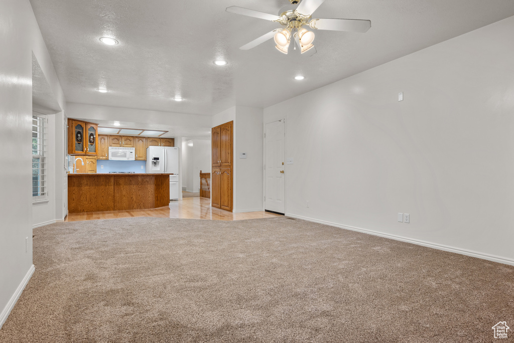Unfurnished living room with light carpet, recessed lighting, and a ceiling fan