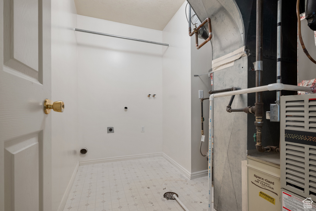 Laundry area featuring tile patterned floors, hookup for an electric dryer, and heating unit