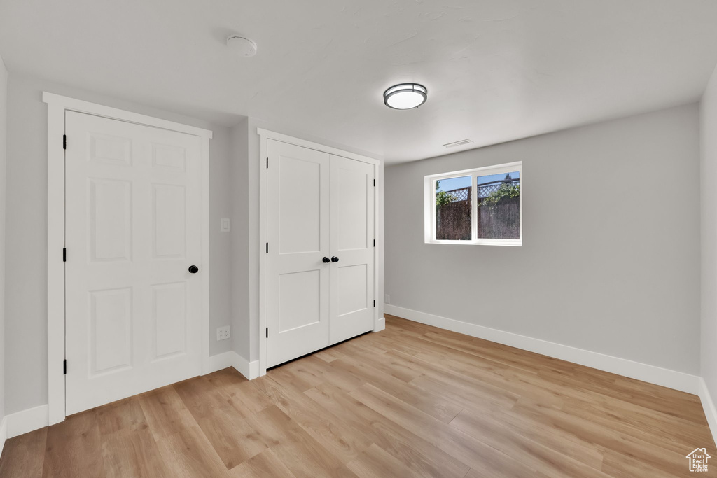 Unfurnished bedroom featuring light wood-style flooring and a closet
