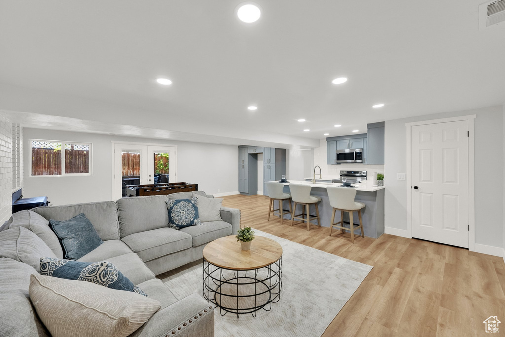 Living room with light wood finished floors and recessed lighting