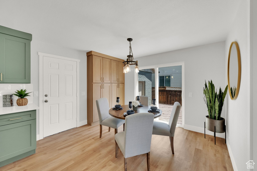 Dining area featuring light wood-type flooring and a chandelier