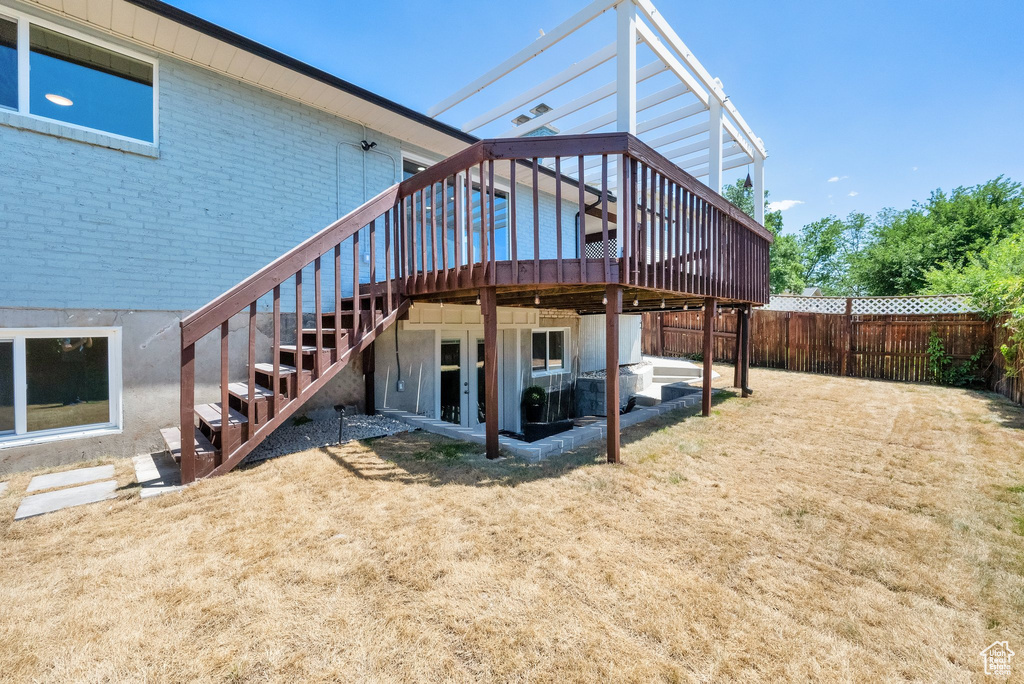 Rear view of property featuring stairway, a wooden deck, brick siding, and a fenced backyard