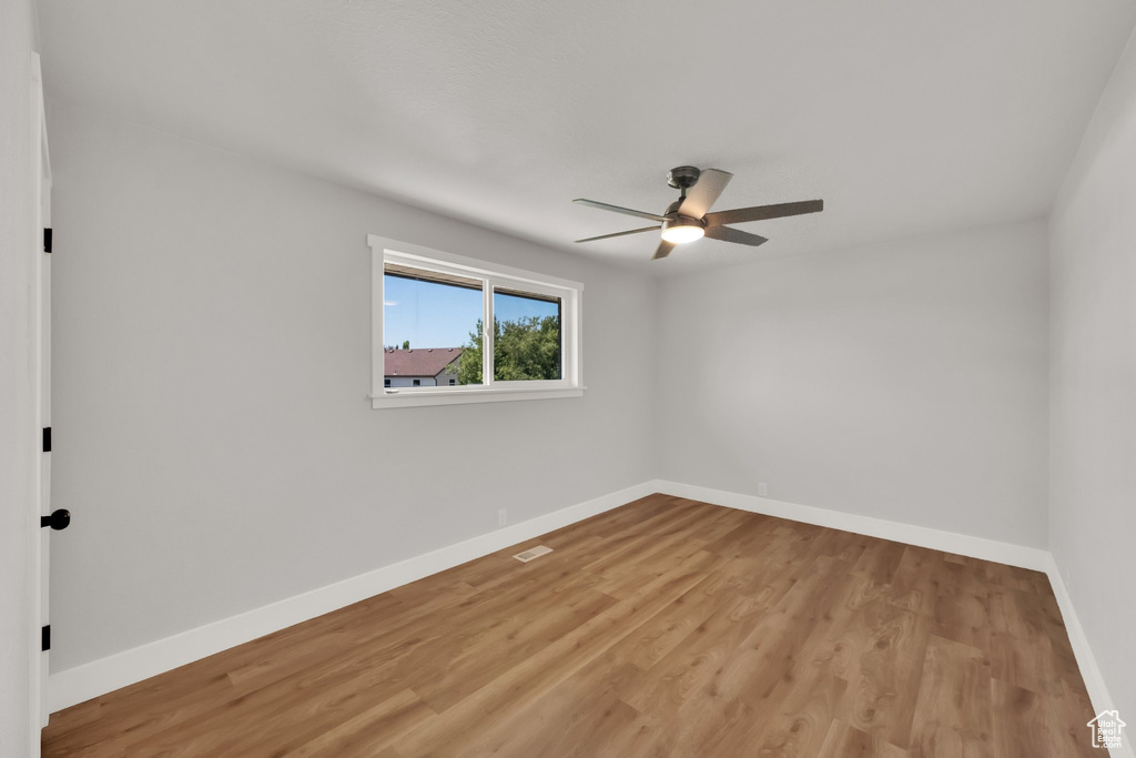 Unfurnished room with a ceiling fan and light wood-type flooring