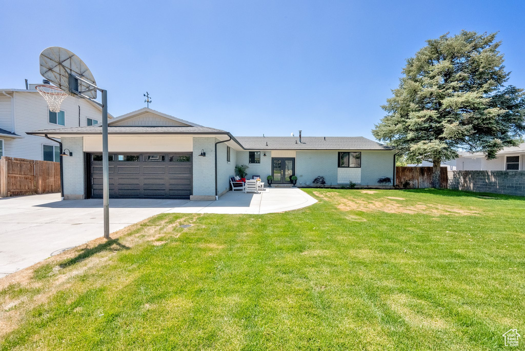 View of front facade with driveway, a garage, and brick siding