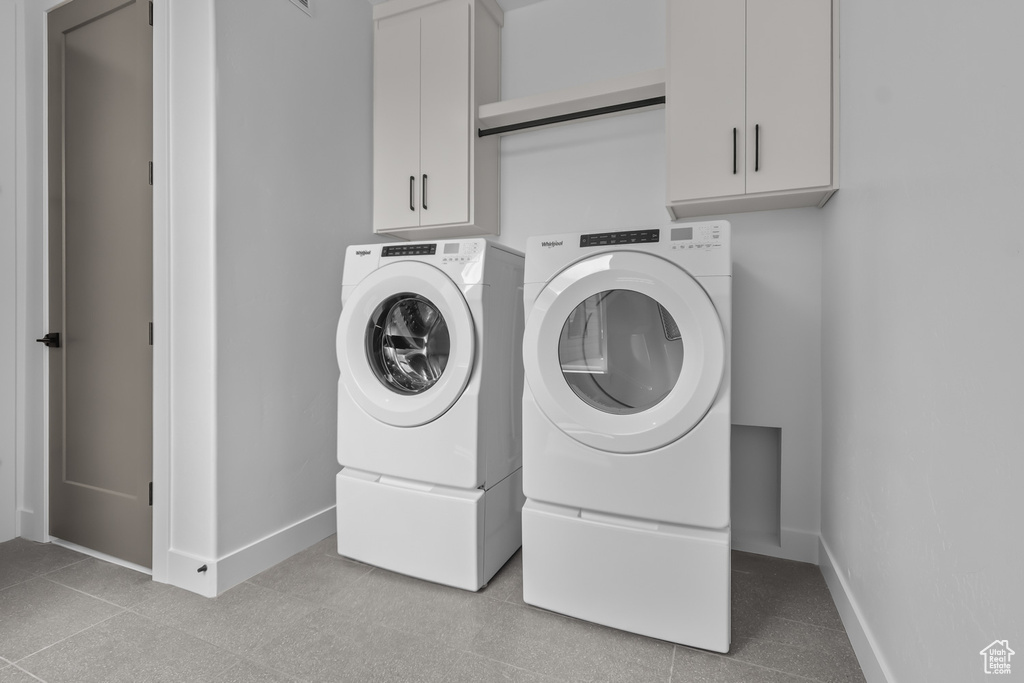 Washroom with washing machine and clothes dryer and cabinet space