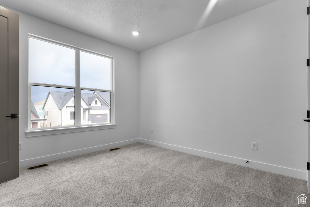 Carpeted empty room featuring baseboards