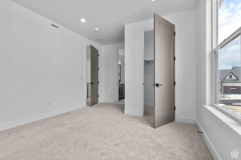 Unfurnished bedroom with light carpet