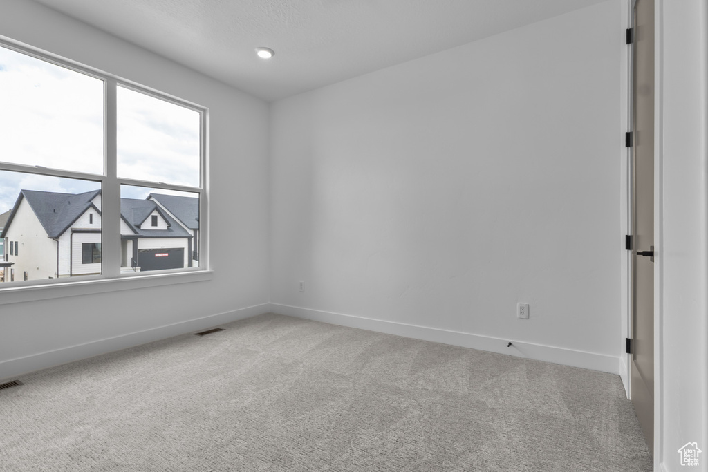 Carpeted spare room with baseboards