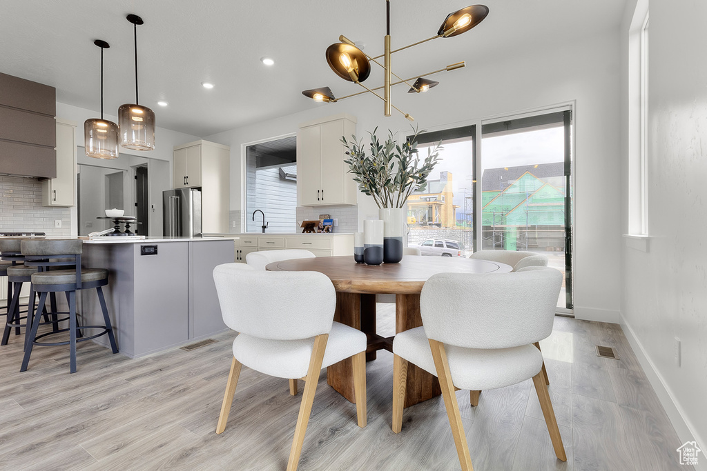 Dining room featuring light wood finished floors, healthy amount of natural light, and recessed lighting