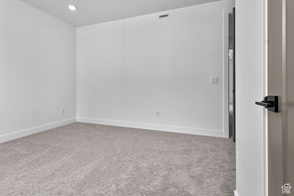 Carpeted spare room featuring baseboards and recessed lighting