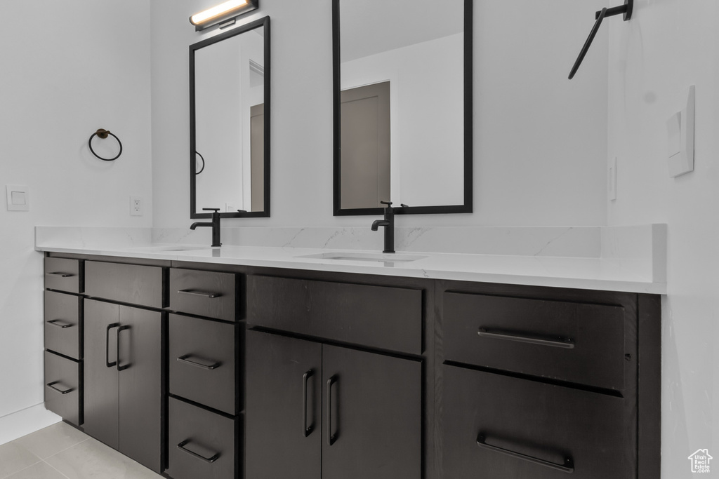 Bathroom with double vanity and tile patterned flooring