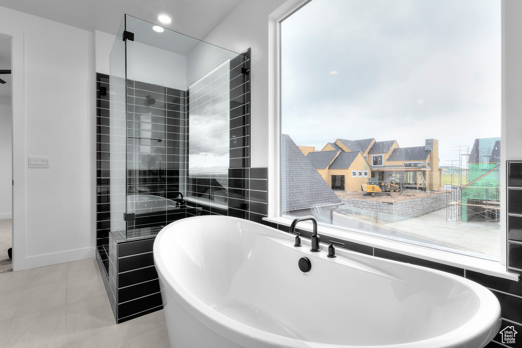 Bathroom with a freestanding tub, tile patterned flooring, and a stall shower