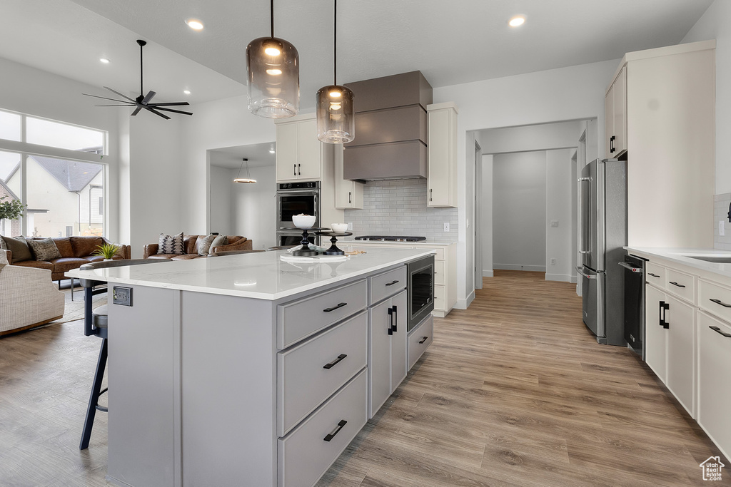 Kitchen with a kitchen breakfast bar, stainless steel appliances, open floor plan, ceiling fan, and a kitchen island