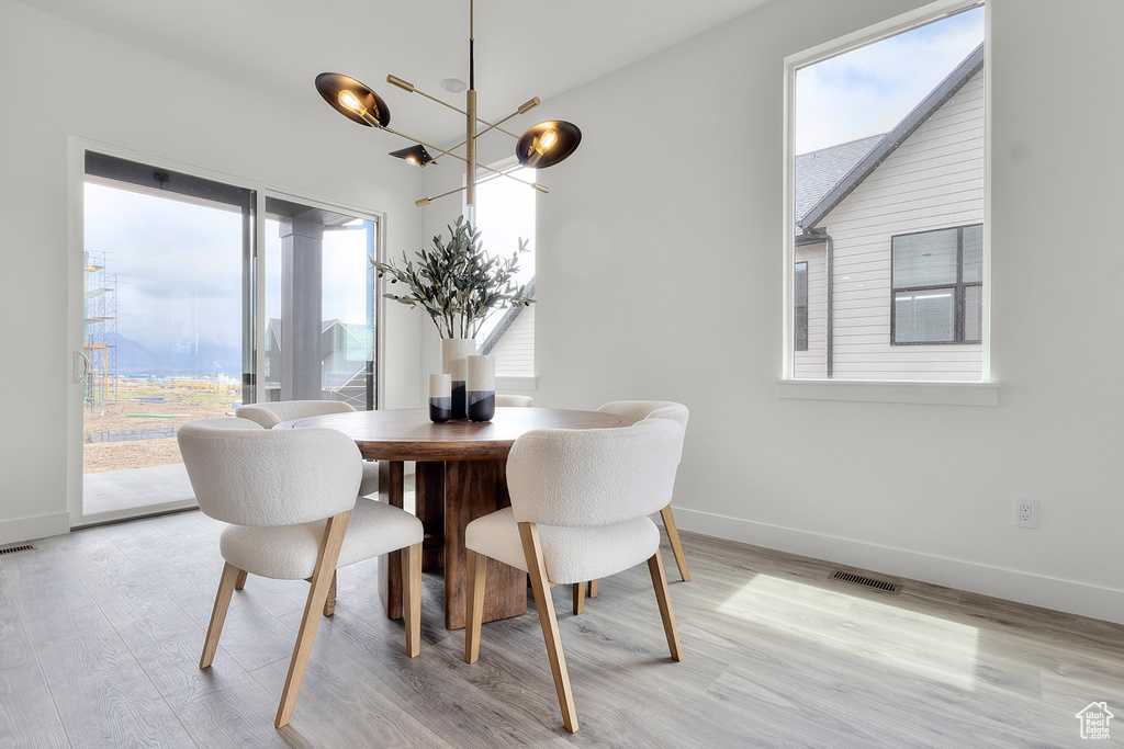 Dining area with light wood-style floors and a chandelier