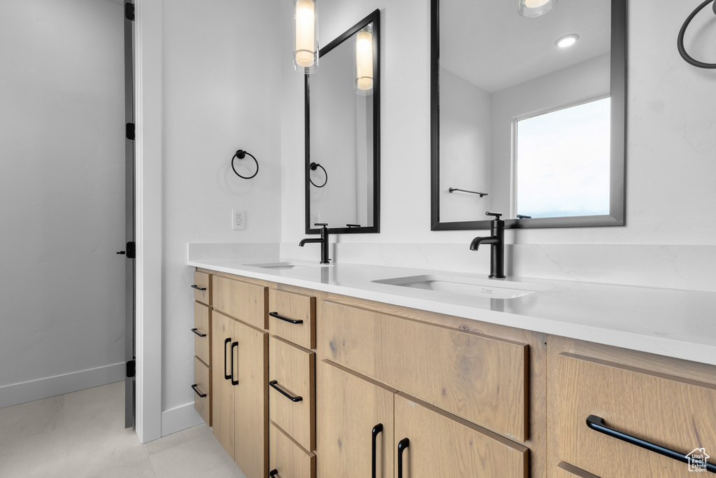 Full bath with double vanity and baseboards