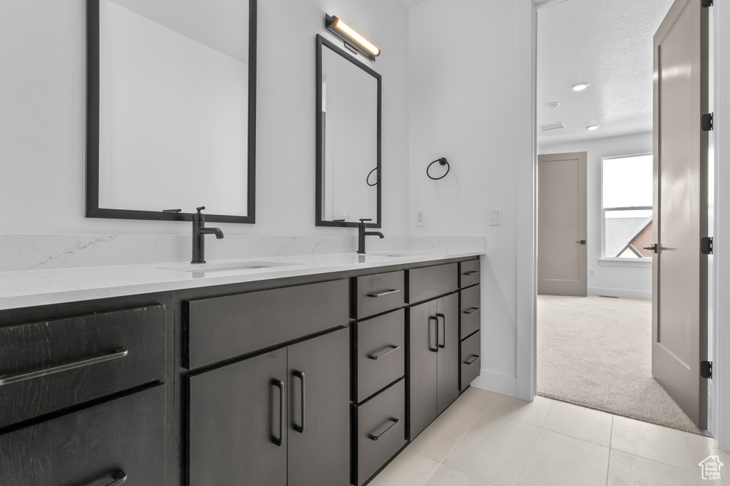Full bath with double vanity and tile patterned floors