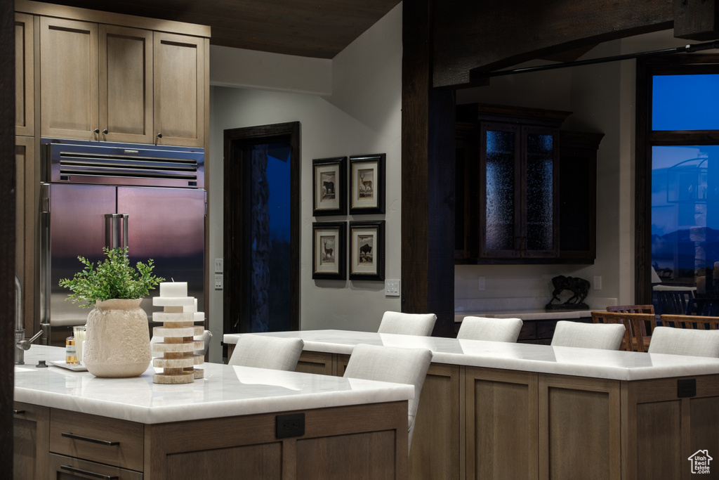 Kitchen featuring built in fridge and light countertops