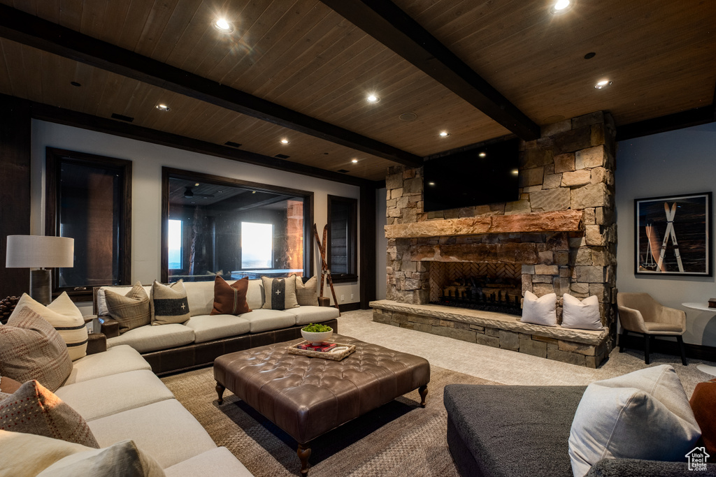 Living area with carpet, a wooden ceiling with exposed beams, a fireplace, and recessed lighting