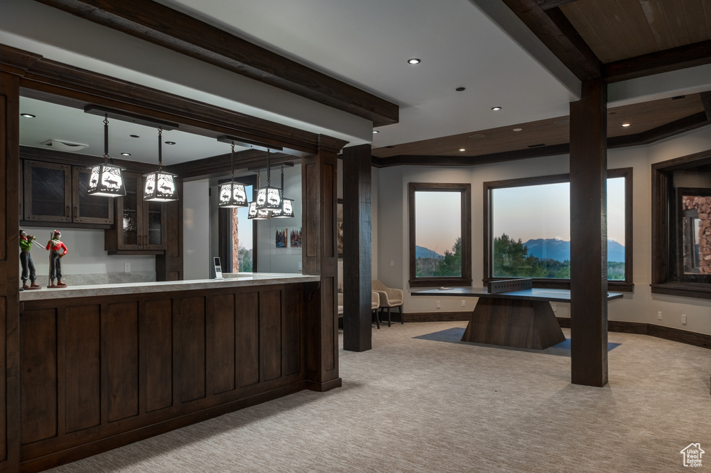 Kitchen featuring dark brown cabinets, light colored carpet, glass insert cabinets, beam ceiling, and recessed lighting