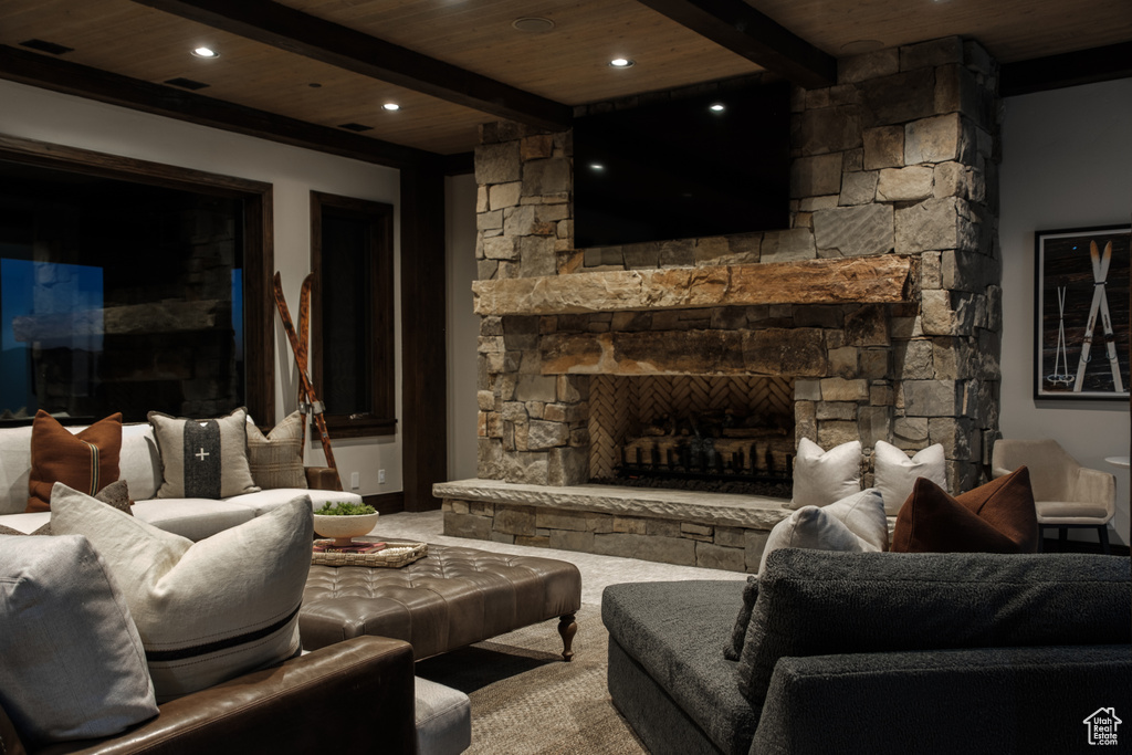 Living room with a wooden ceiling with exposed beams, a fireplace, carpet, and recessed lighting