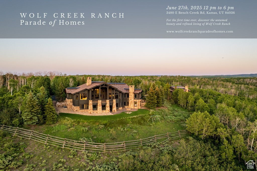 Rear view of property featuring a chimney, a wooded view, and a wooden deck