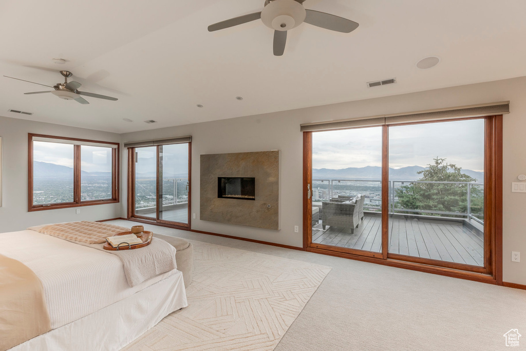 Bedroom featuring access to exterior, multiple windows, a mountain view, and carpet flooring