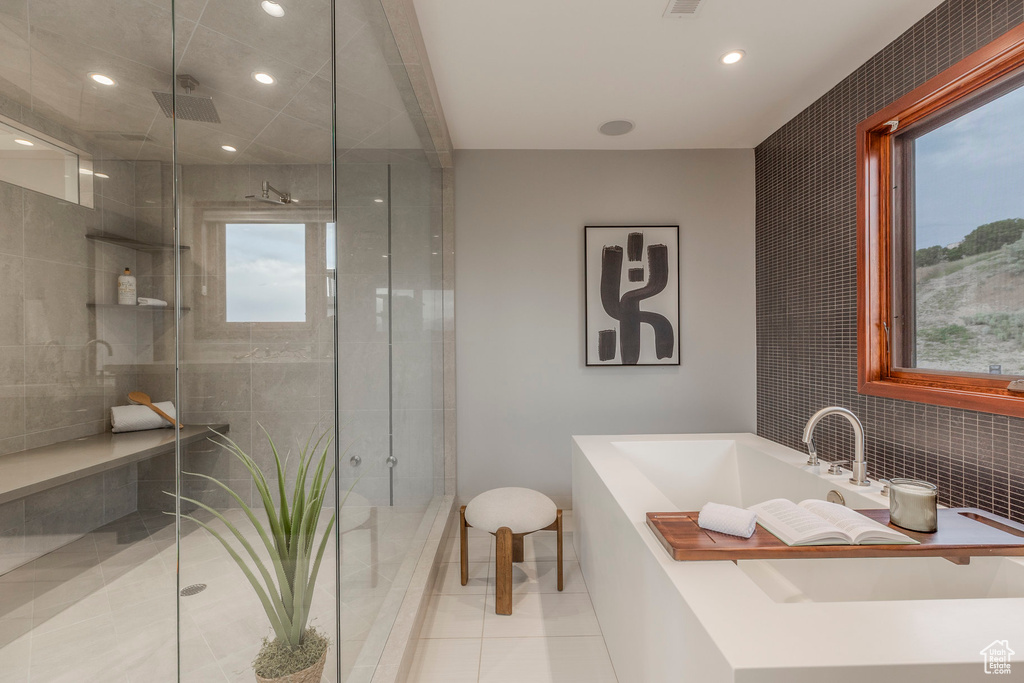 Bathroom with a freestanding bath, a stall shower, recessed lighting, and tile patterned floors