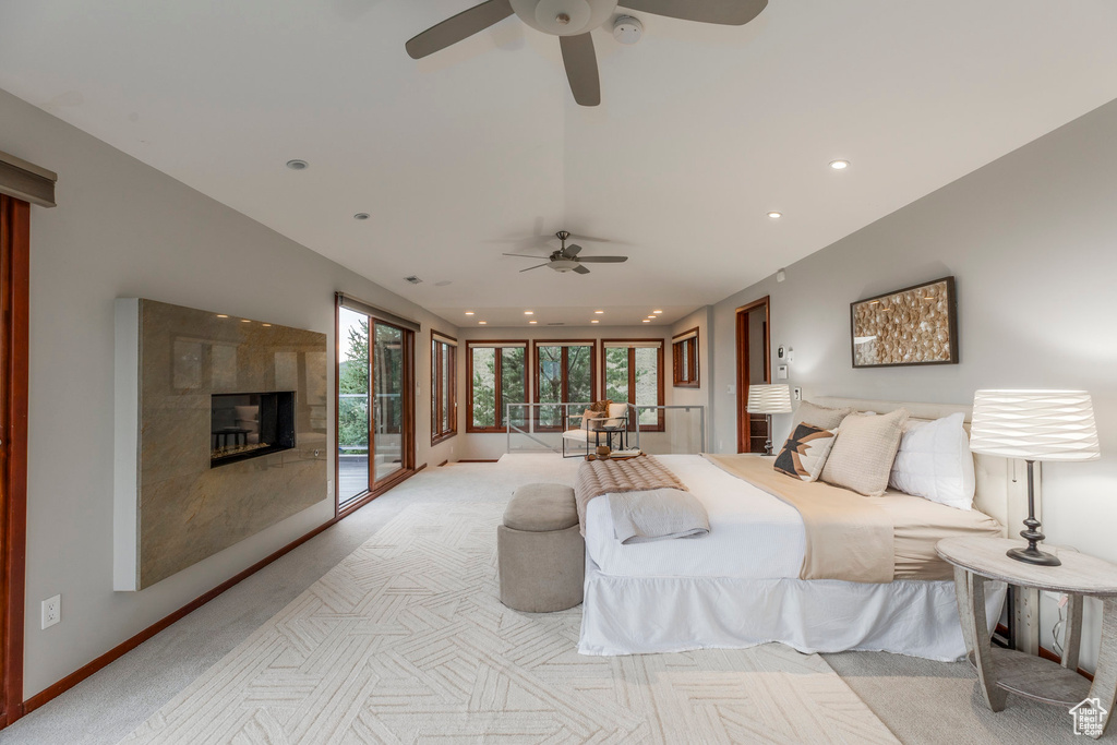 Bedroom featuring light carpet, access to exterior, a tile fireplace, and recessed lighting