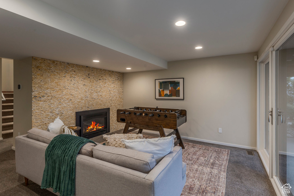 Living area with recessed lighting, dark colored carpet, a glass covered fireplace, and stairway