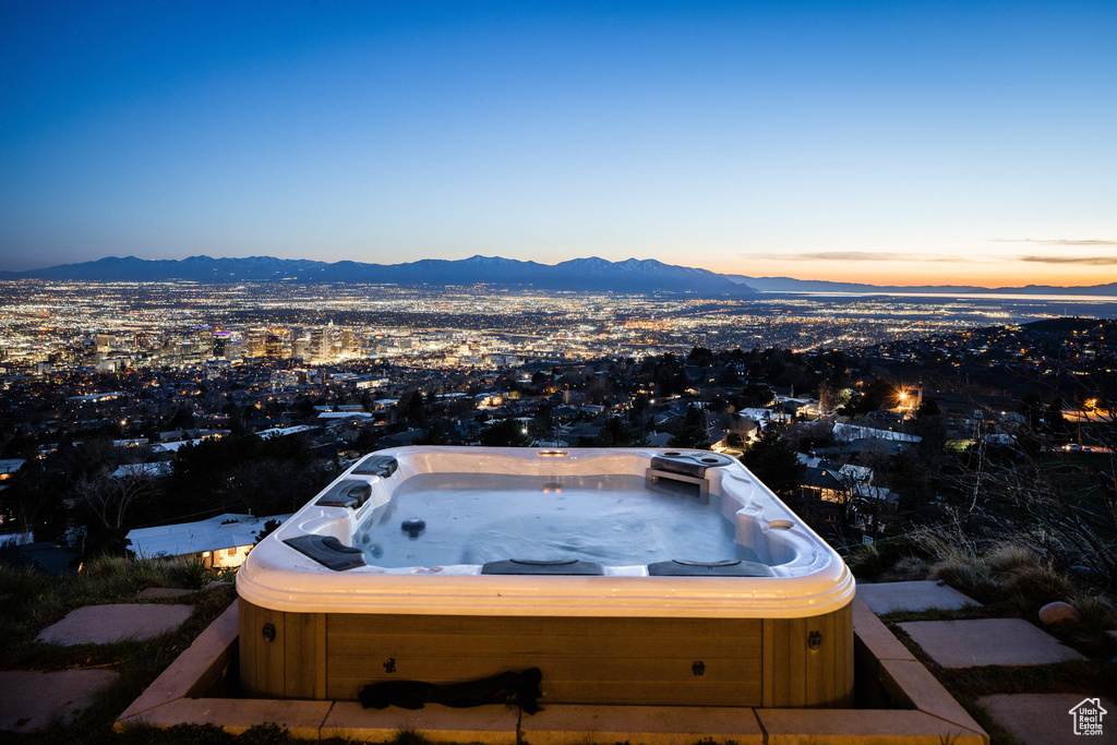 Exterior space with a hot tub and a mountain view