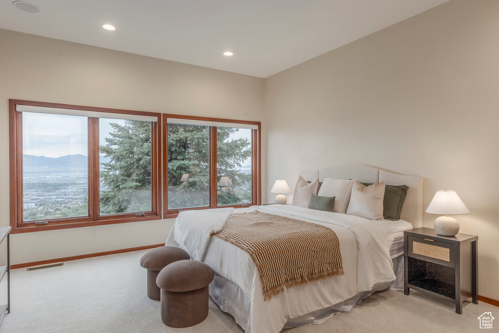 Carpeted bedroom with multiple windows and recessed lighting
