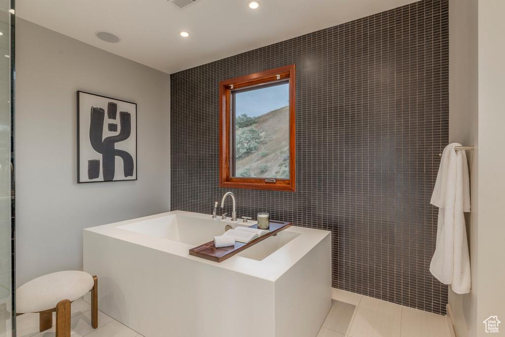 Full bathroom with tile walls, recessed lighting, tile patterned floors, and a bath