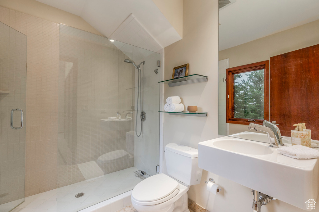 Bathroom with a stall shower and lofted ceiling